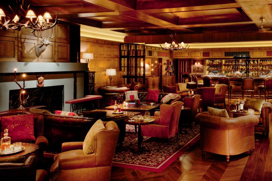 The Macallan Whisky Bar & Lounge, a rustic lounge with wooden interiors, leather armchairs and warm lighting.