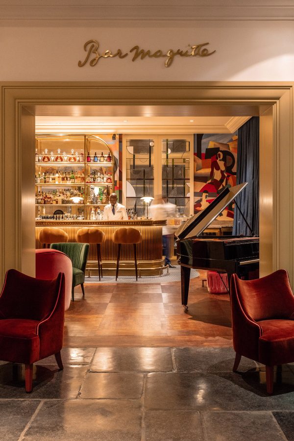 Bar Margritte’s interior has plush chairs and a grand piano placed around a bar. 