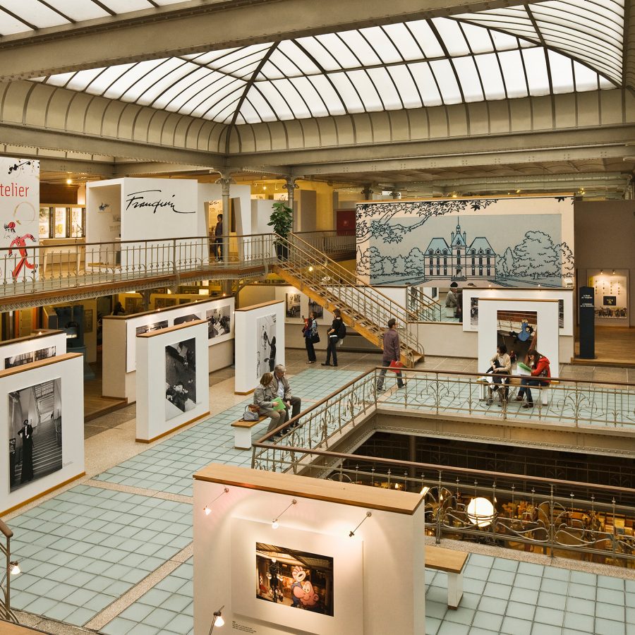 The interior of an exhibition in Brussels shows displays of photos and prints.