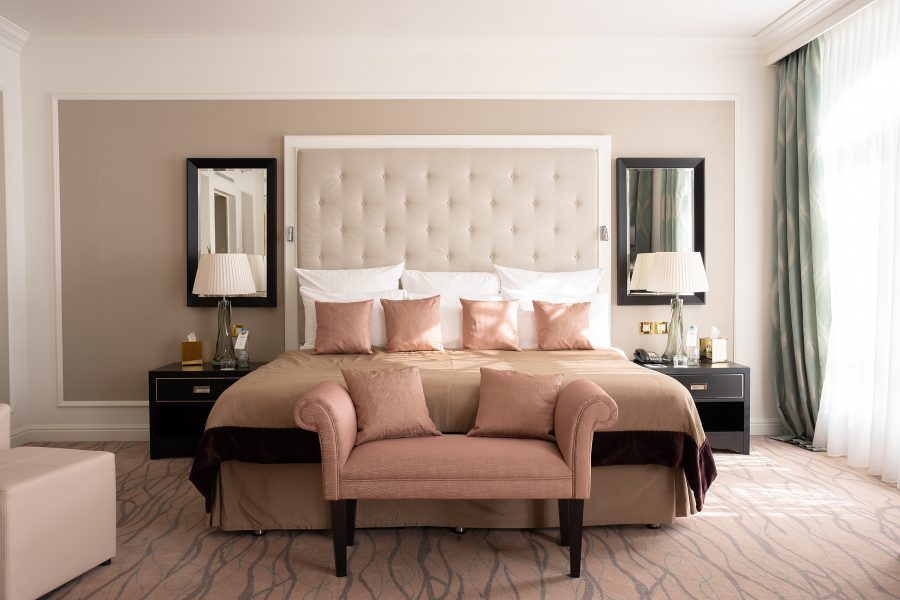 The interior of a guest room at Steigenberger Icon Wiltcher’s features a beige bed with neutral walls and floors.