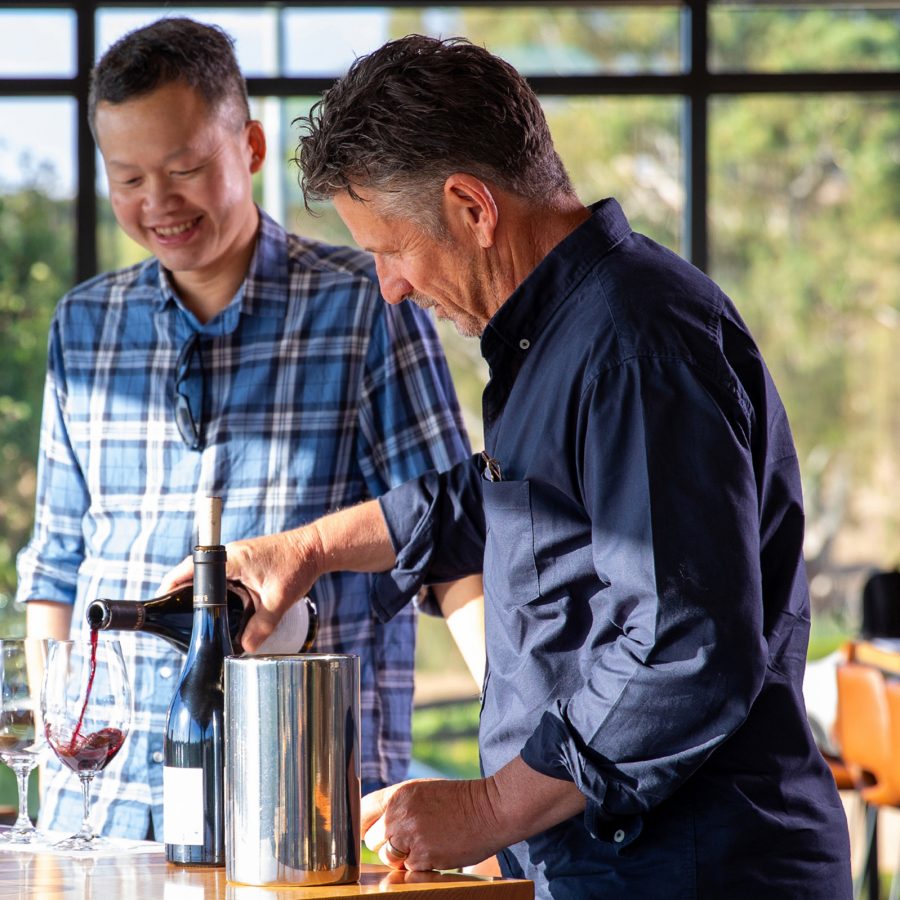 Cathay Pacific’s Ronald Khoo and Vinarchy’s Craig Stansborough tasting and blending red wines together in a brightly lit room on a sunny day