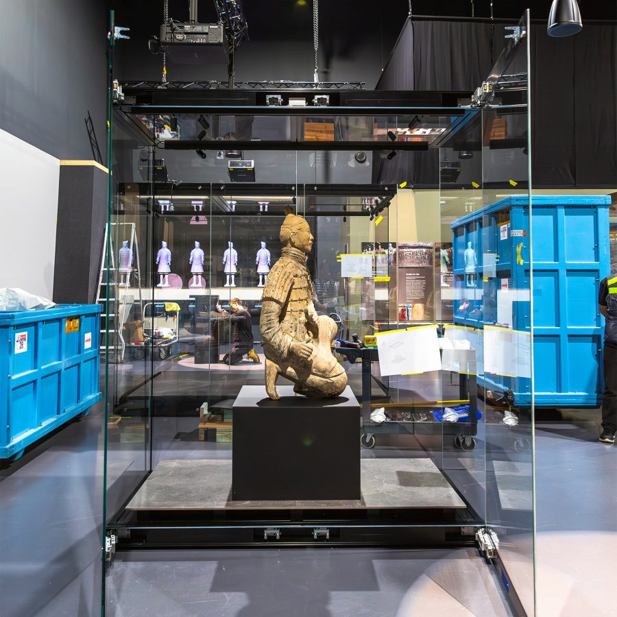 A Terracotta Warrior statue is placed inside a large glass display case at a museum exhibit in Australia