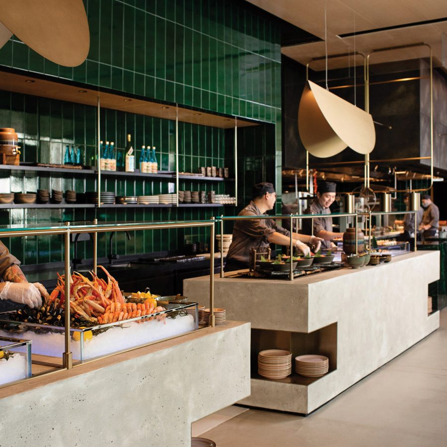 Chefs preparing behind the buffet counter inside FEAST at East Hotel
