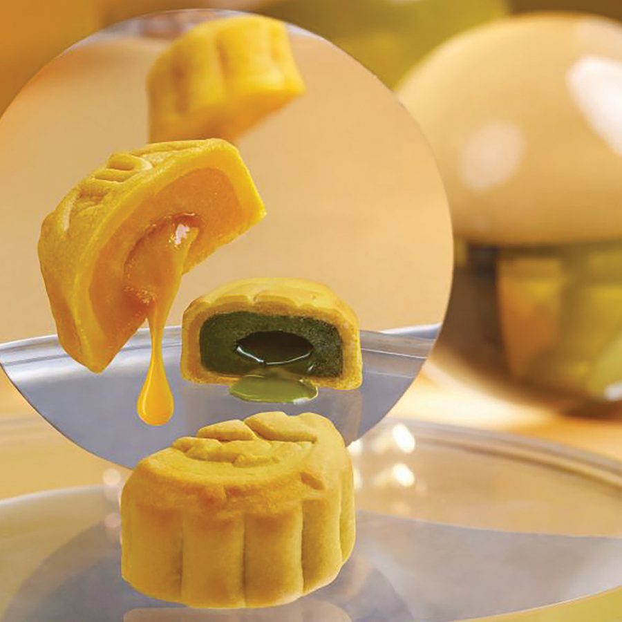 A closeup of modern mooncakes sliced in half with custard and green tea oozing out, served at Imperial Patisserie