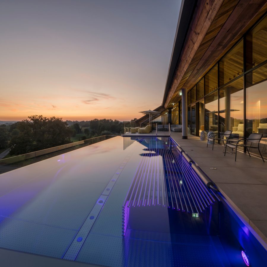 Exterior view at sunset of an outdoor sky pool and deck.