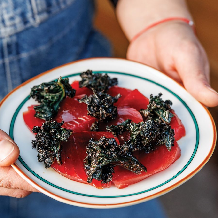 Person carrying a red and dark green dish at Enoteca L’antidoto in Rome.