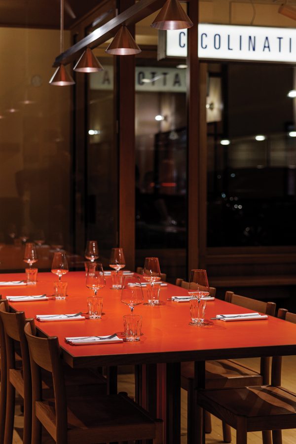 A wooden table arranged with wine glasses and cutlery at SantoPalato.