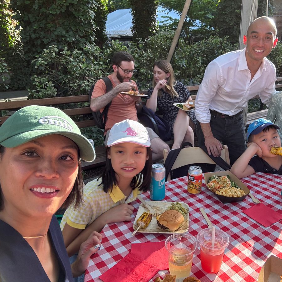  Juan, his wife and his three children smile while having lunch at a picnic table in New York. 