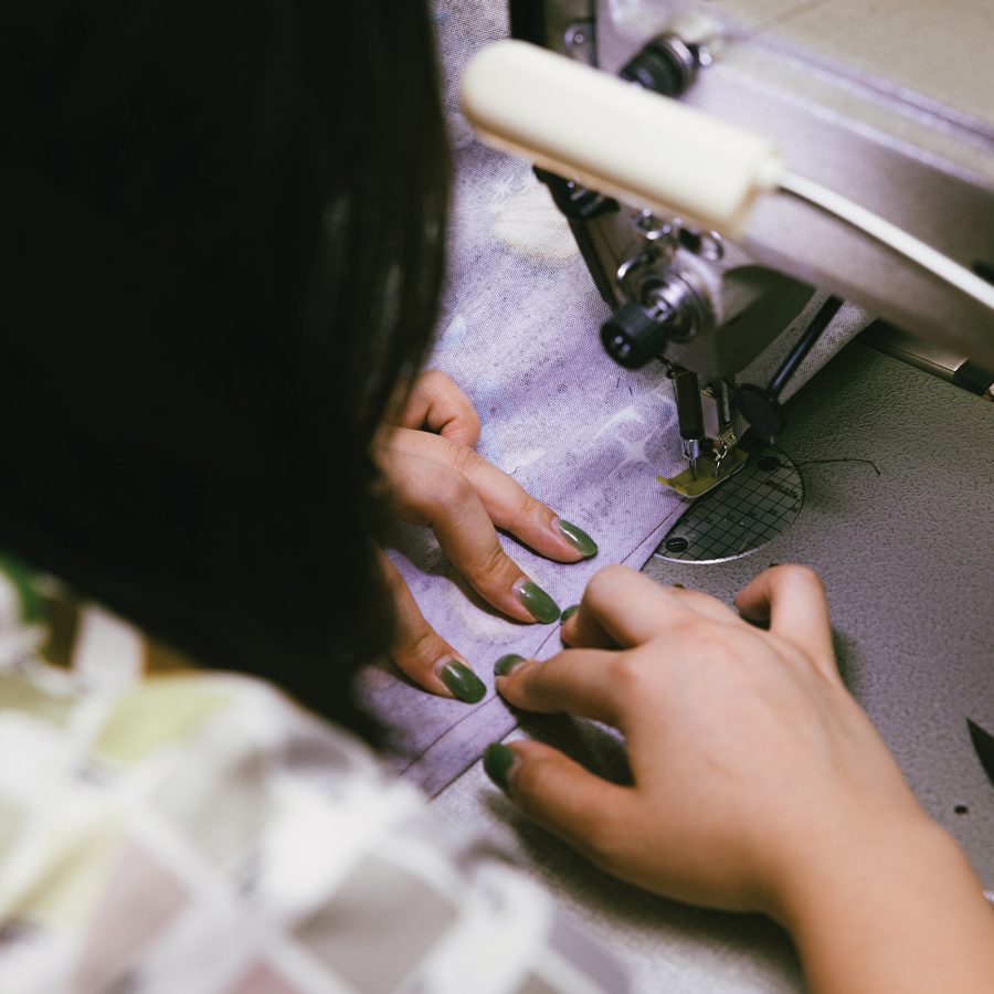 Chocolate Tsang, creator of Stand Tall D, works on a cheongsam with a sewing machine.