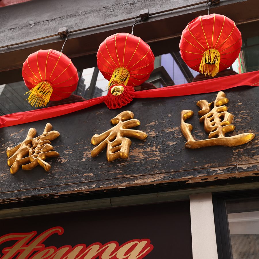 The wooden signboard of Lin Heung Tea House hangs from its shopfront.