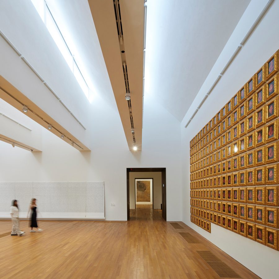  The interior of a gallery in M+ shows pieces hanging from a white wall. 