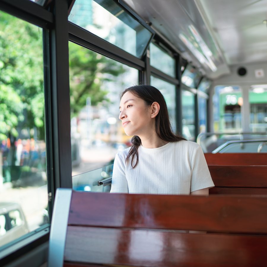 A passenger on the tram looks out the window, smiling. 