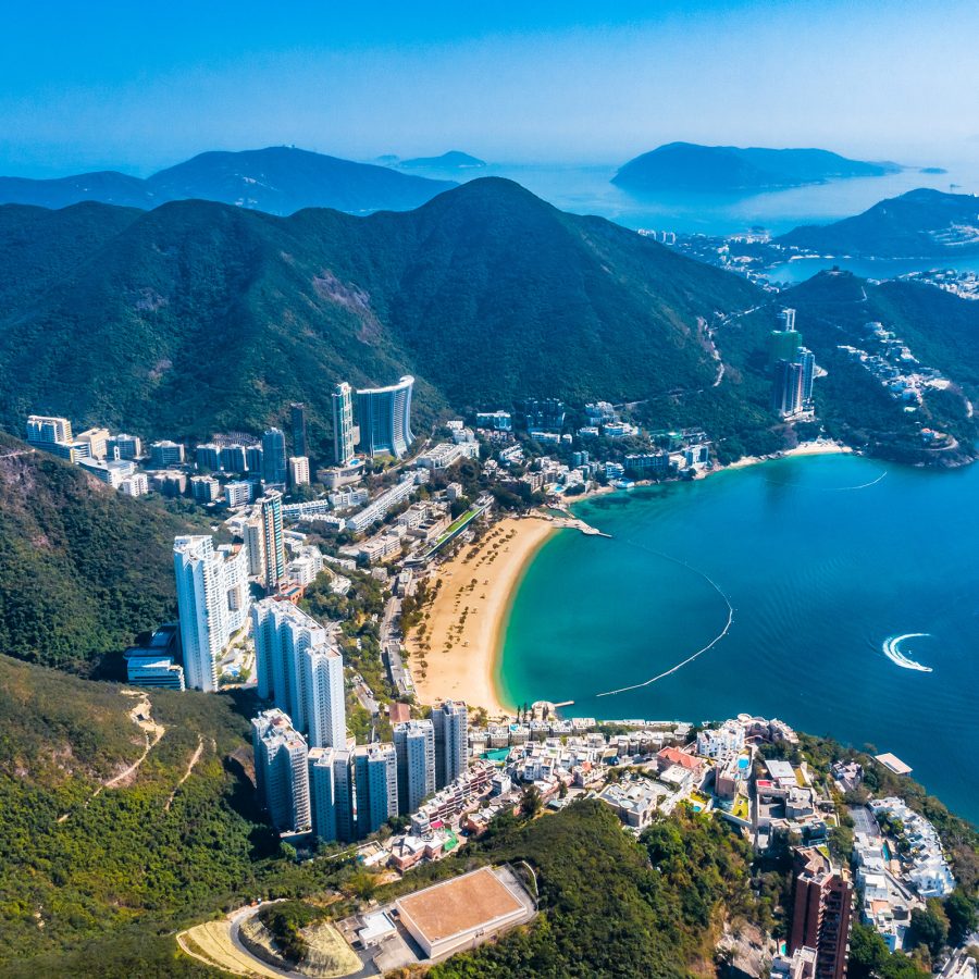 Repulse Bay is a stretch of golden sand bordered by tall residential buildings and mountains on one side, and water on the other.