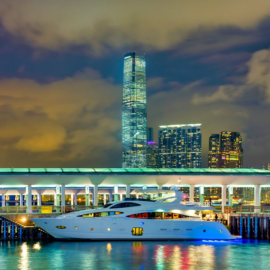 A white junk boat at Central harbour dock in the night. 