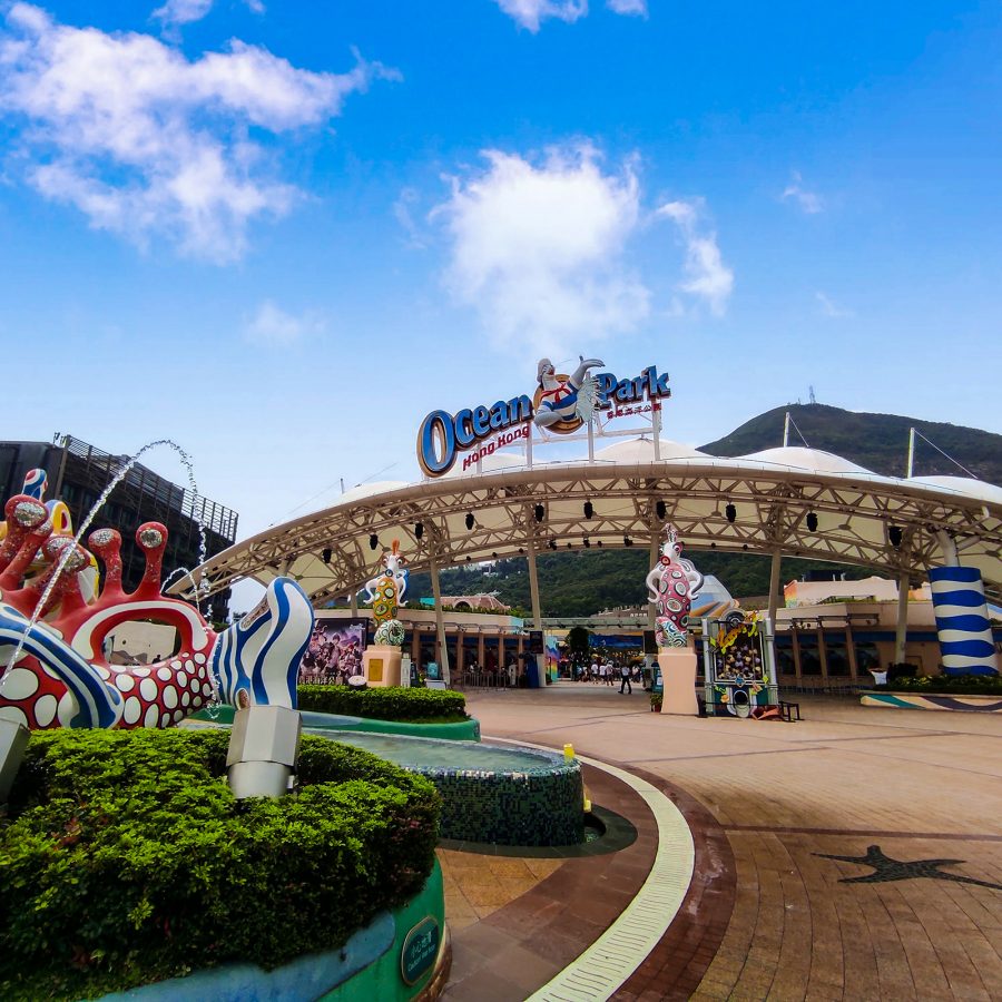 The entrance of Ocean Park features sculptures and a large white tent beneath a large sign. 