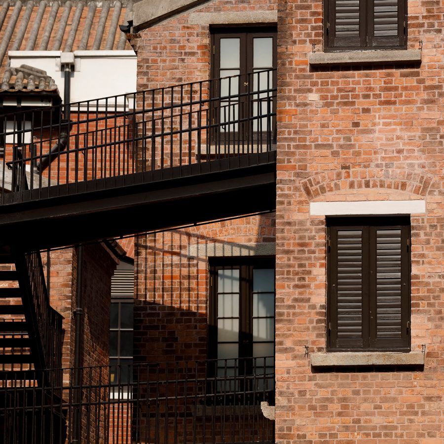 Tai Kwun’s brick wall exterior is seen connecting to a walkway. 