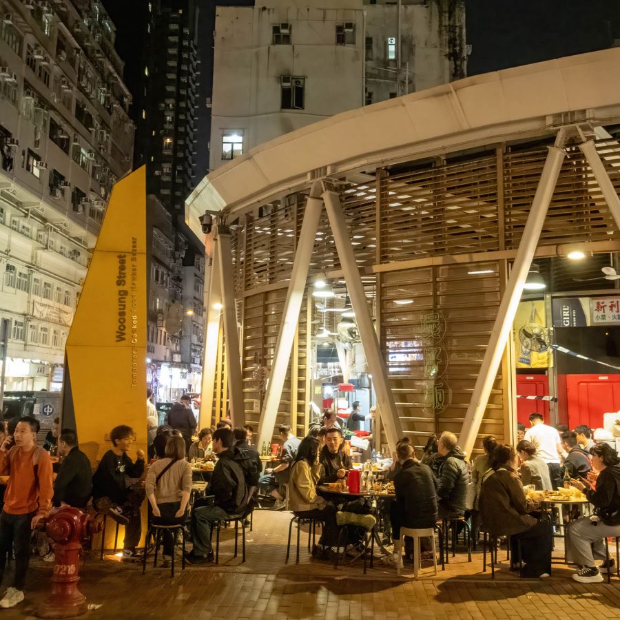 People are gathered around tables at a dai pai dong.
