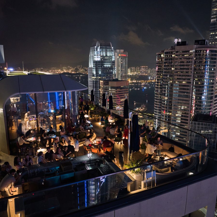 People dine outdoors in dim lighting at Cardinal Point at night.  