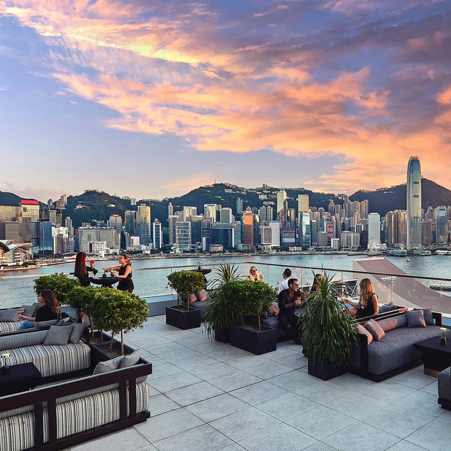 People dine at low tables in the open air above Hong Kong at Aqua Spirit. 
