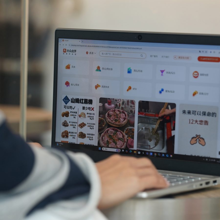 A man browsing Dianping on his laptop.