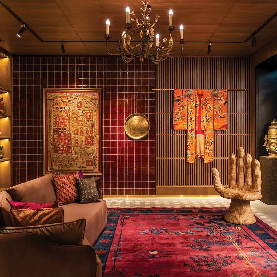 A section of Nilaya Anthology appears to showcase a hand-like chair, robes, various collectibles and a wide sofa.