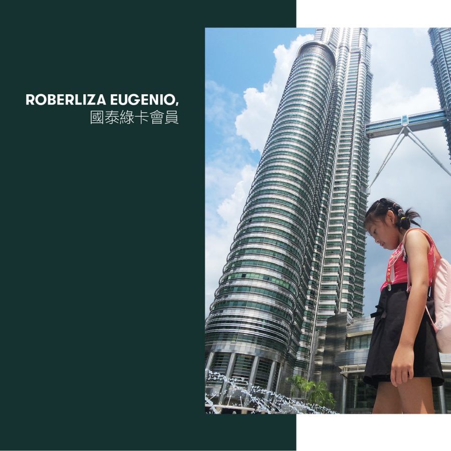 A young girl standing in front of the Petronas Twin Towers, Kuala Lumpur. 