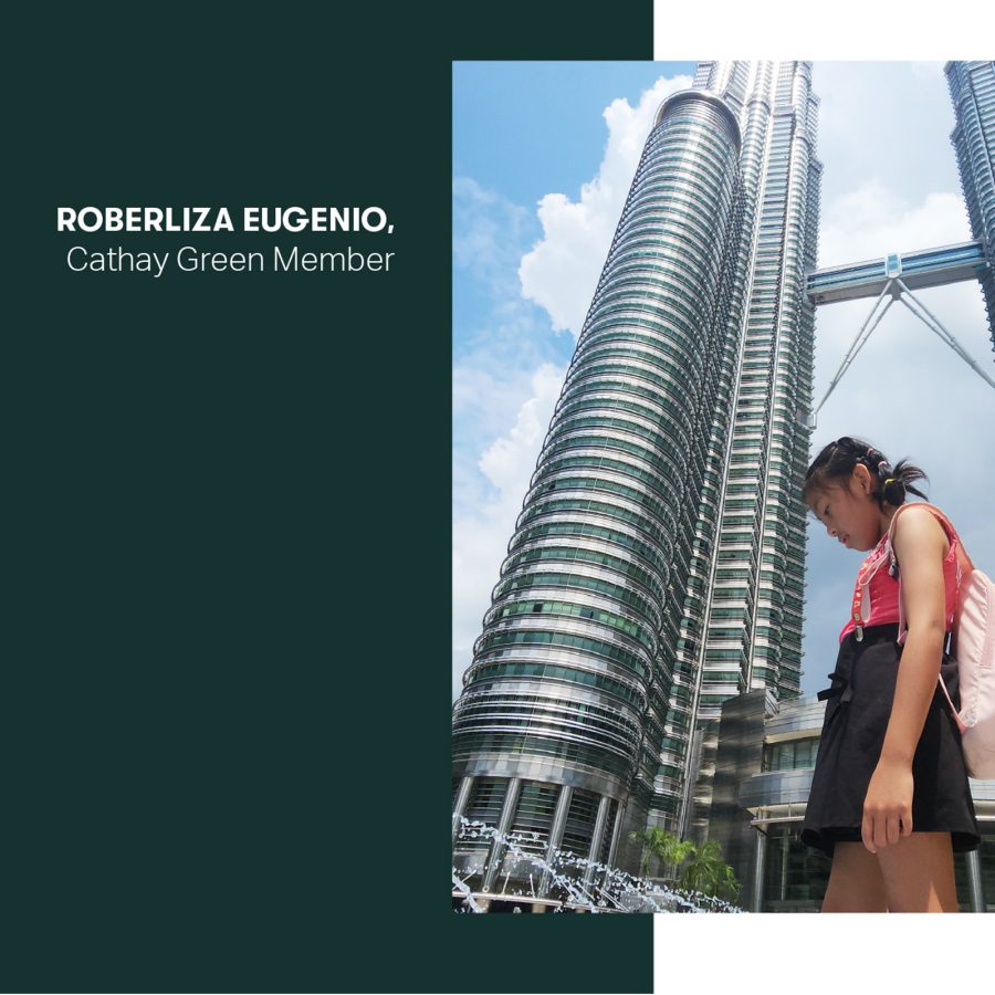 A young girl standing in front of the Petronas Twin Towers, Kuala Lumpur. 