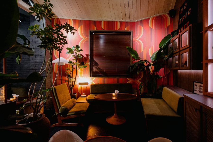 A table, sofas, colourful walls and plants in the interior of Epic, Shanghai. 