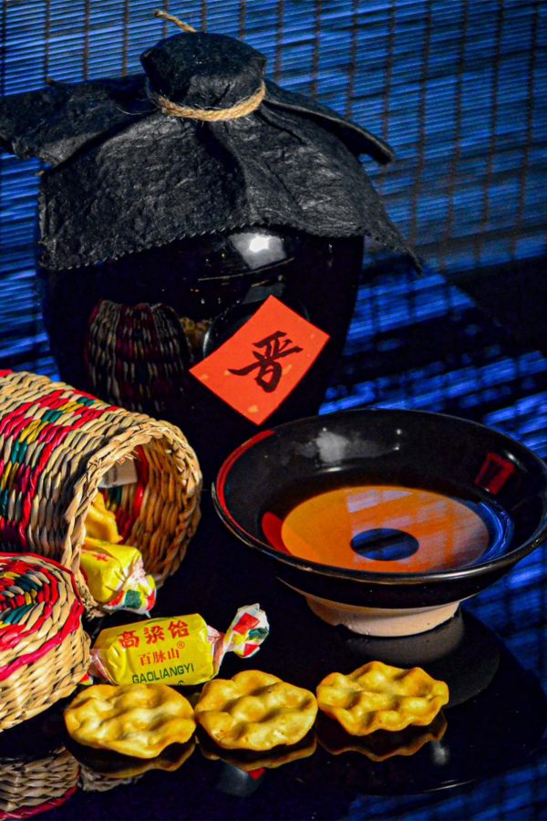 Closeup of a bowl of  Chinese wine and Chinese wine jar with traditional Chinese candy on the side, served at Healer bar in Shanghai. 