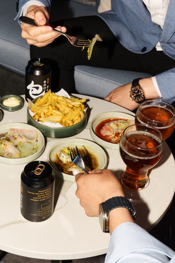 Men wearing watches dig into bar snacks and beers at East Hong Kong.