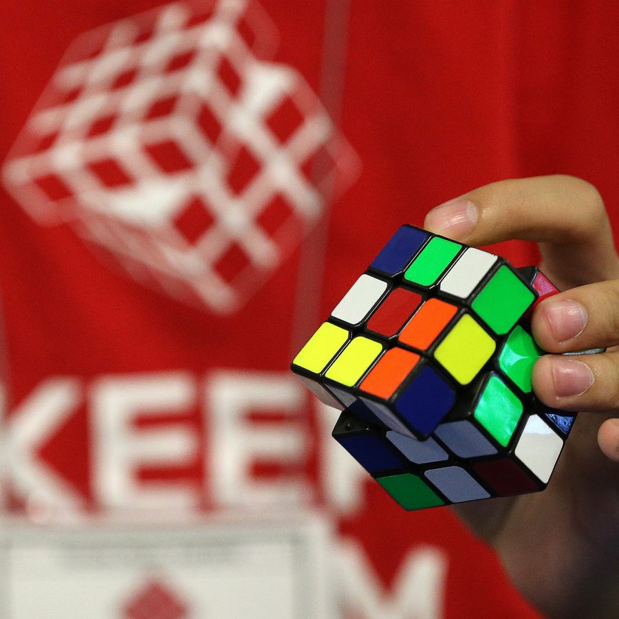 A hand is shown fiddling with a Rubik’s Cube, the inanimate star of the Zhuhai Open 2025 Speedcubing Competition in June. 