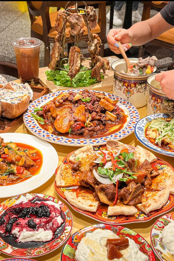 Saucy dishes, including dapanji, cover the surface of a dining table in Ma Fenghua Xinjiang Cuisine in Xinjiang.  