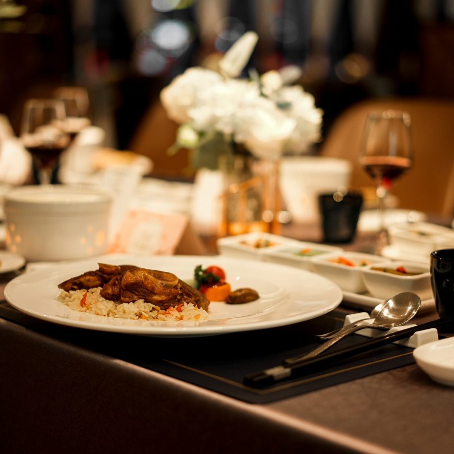 A meal including Uyghur polo is served at a dining table.