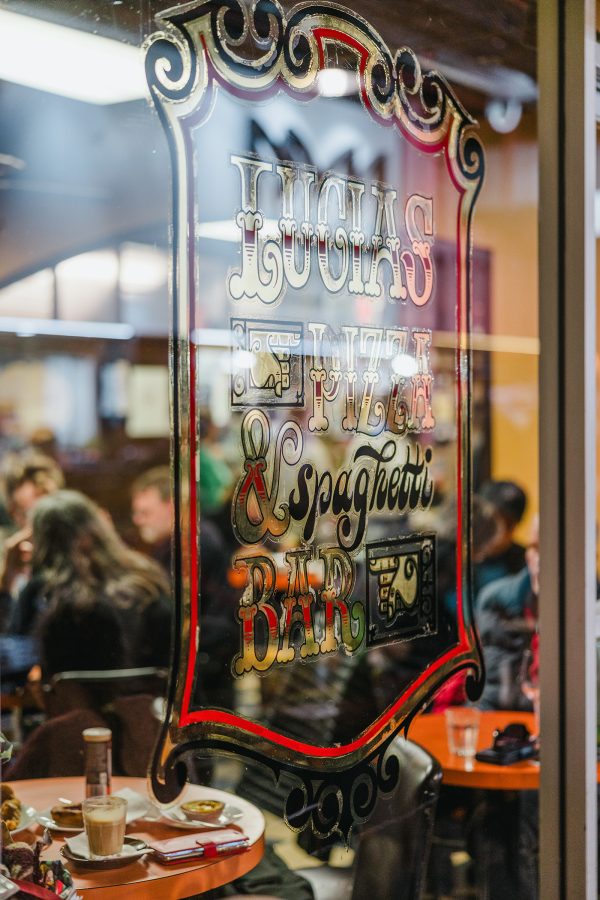 Shot of a glass wall covered in a painted red sign at Lucia’s Pizza and Spaghetti Bar in Adelaide.