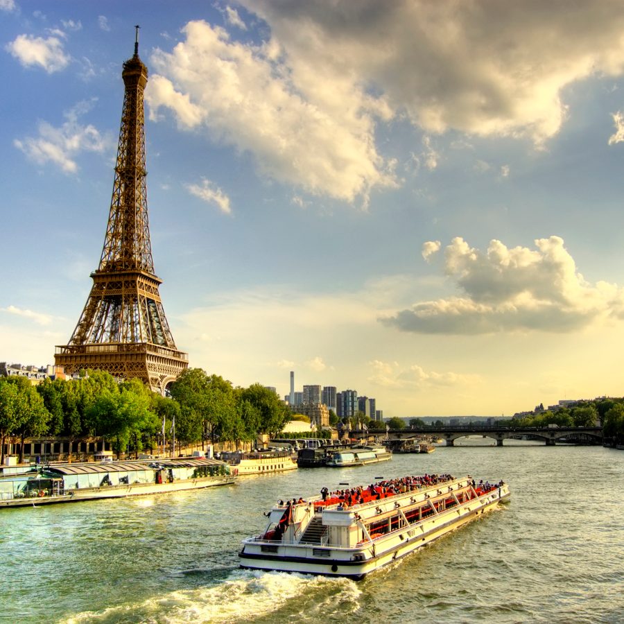 A riverboat sails along the Seine and the Eiffel Tower in Paris.  