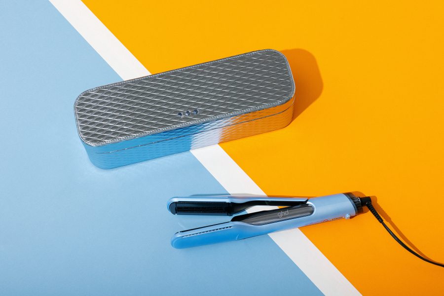 The Ghd Iced Luxe Duet Style and its matching vanity case on blue and orange sports flooring. 