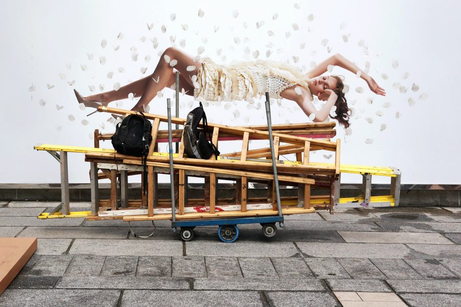 A model on a billboard seemingly floats above a pile of ladders in Hong Kong.