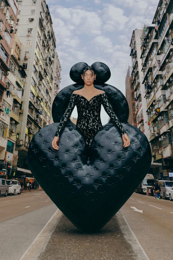 A model stands in the middle of a Hong Kong street dressed in a black balloon-esque outfit . 