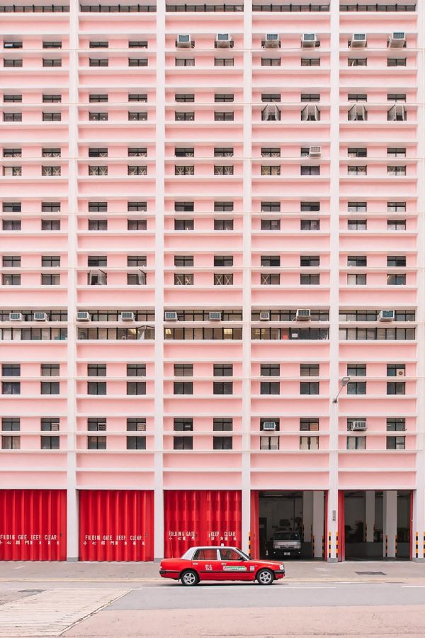 A red taxi drives past the pastel pink Wan Chai fire station in Hong Kong.