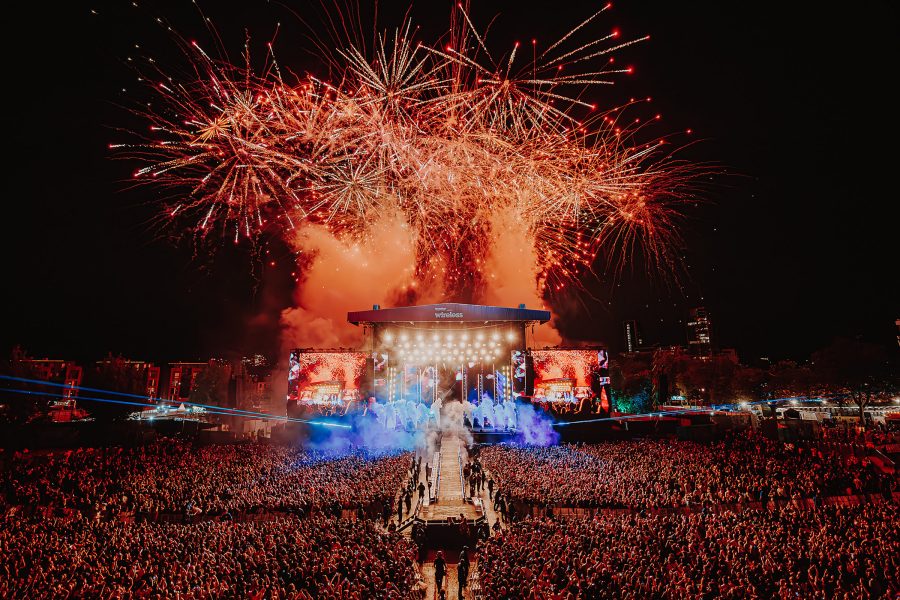 Fireworks exploding over a crowd and the main stage at Wireless Festival. 
