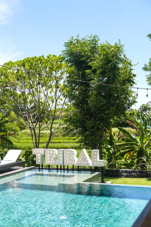 Embellished letters spell out “Tribal” next to a swimming pool.  