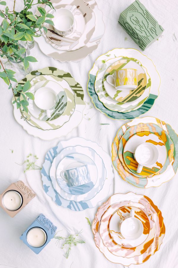Colourful patterned plates, cups and candle holders from Alim·Adil on a white surface.