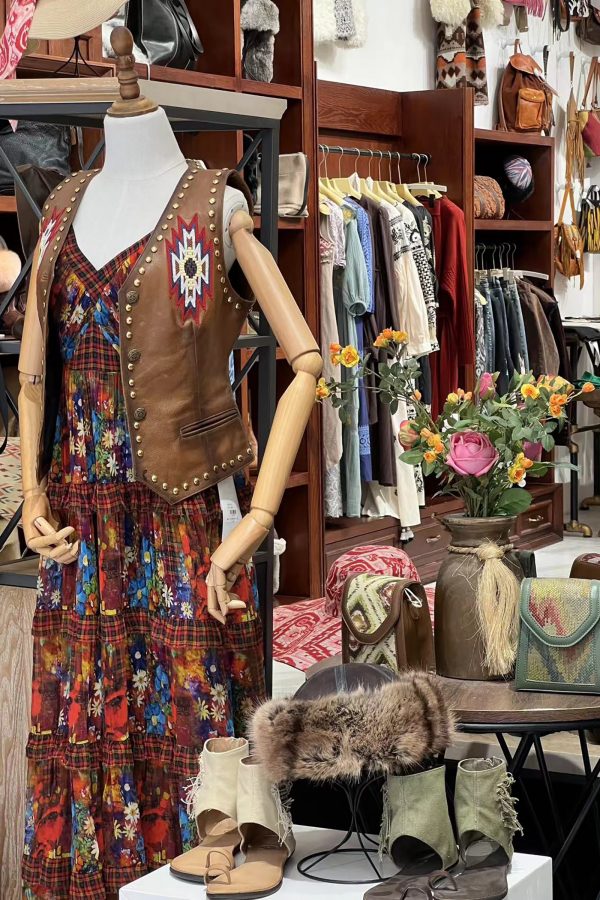 The interior of the Black-Eyed Girl shop with a mannequin, bags and shoes on display, and racks of clothing.