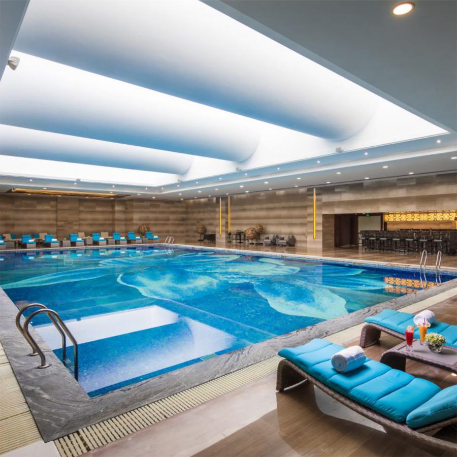 Indoor pool with lounge chairs at Jin Jiang International Hotel Urumqi.