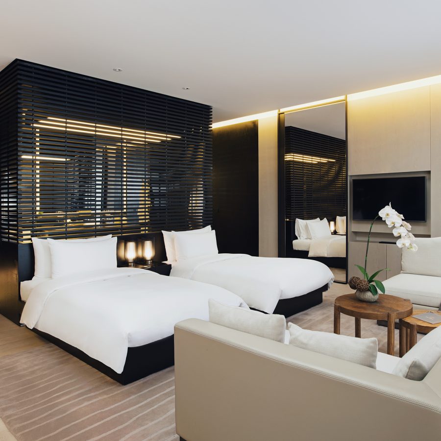 A guest room at The Temple House, Chengdu looks clean and modern and includes two fluffy white guest beds.