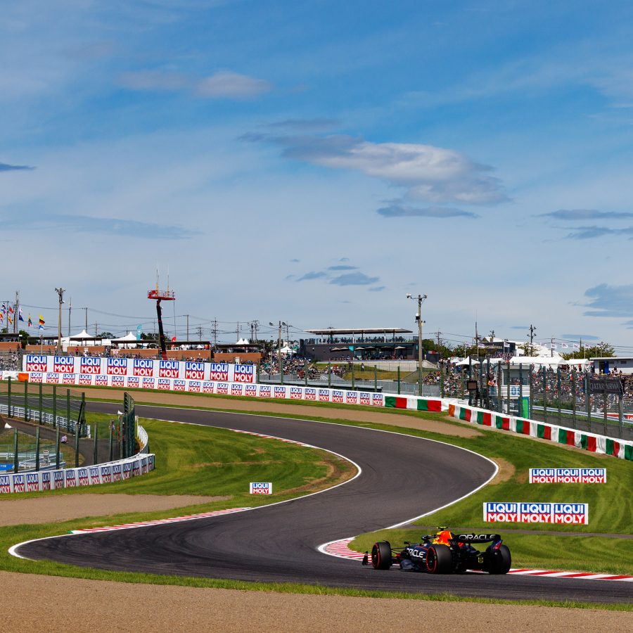 A car on a Formula One racetrack and a Ferris wheel in the distance in Suzuka City, Japan.