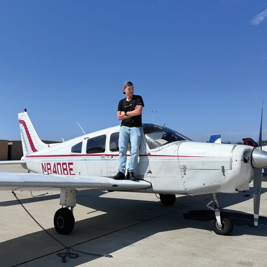 Ona clear day, William Tsai stands on the wing of a small plane parked on a concourse