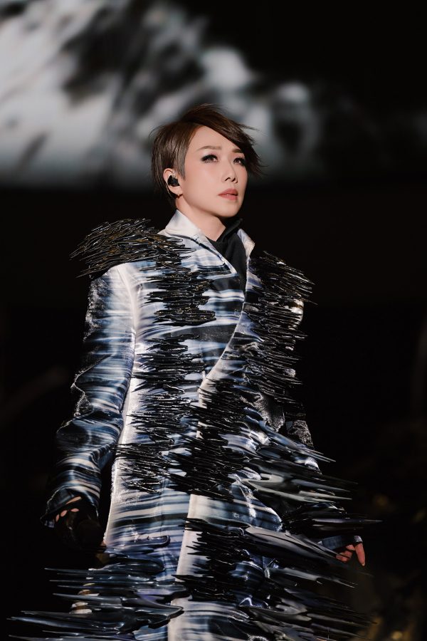 Sandy Lam looks in the distance while on stage during a concert.  