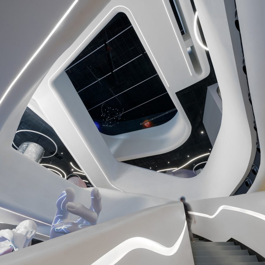 The interior of Shenzhen Science & Technology Museum has a white staircase with a fluid and futuristic design.  