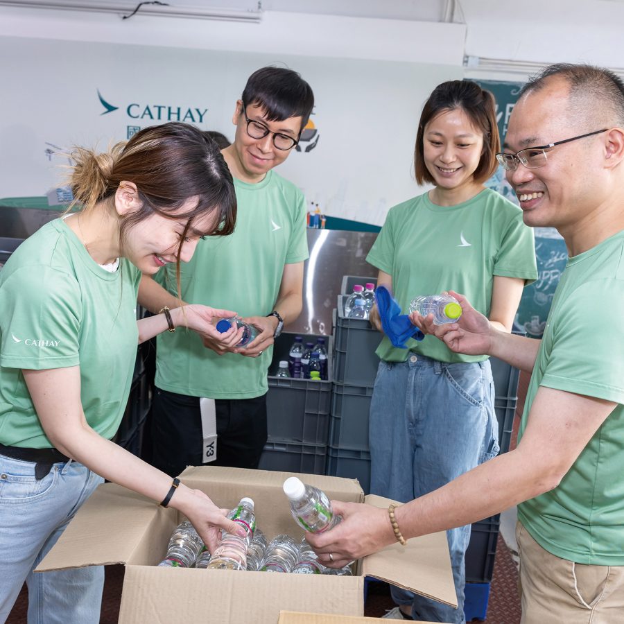 Four Cathay volunteers packing water bottles for Feeding Hong Kong.